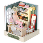 Miniature sewing room set with sewing machine, mirror, and various items in a box labeled 'Beatisfic Atelier'.