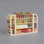 Miniature grocery store shelf with various products on a gray background