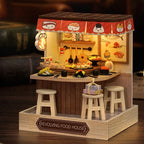 Wooden revolving food house model with stools and miniature food items on a dark background