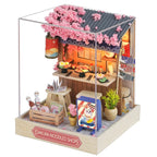 Miniature model of a Sakura Noodles Shop with cherry blossom decorations on a white background
