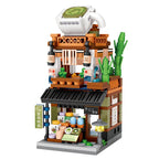 Toy building set resembling a tea shop with a teapot on top, on a white background