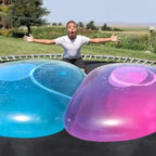 Person on a trampoline with large blue and pink bubbles in front
