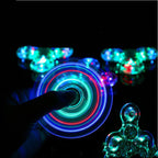 Colorful LED spinner being held with blurred glowing lights in the background