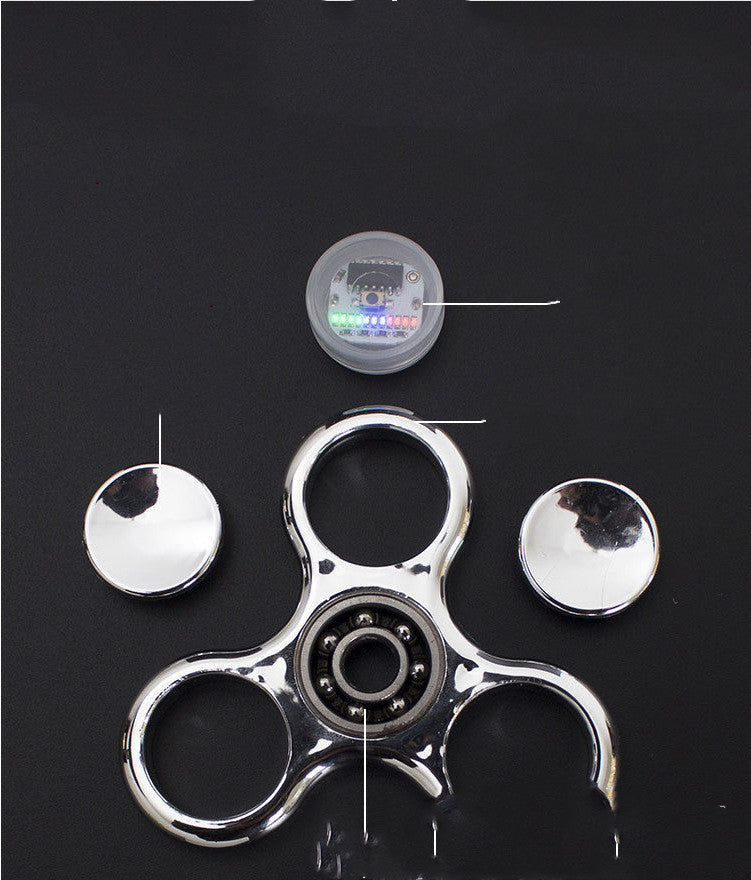 Metallic fidget spinner with bearings on a black background