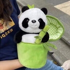 Plush panda toy held by a person wearing a blue shirt with a cartoon character.