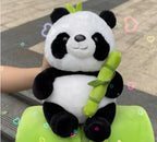 Plush panda toy holding a bamboo stick on a green cushion with a colorful heart pattern.