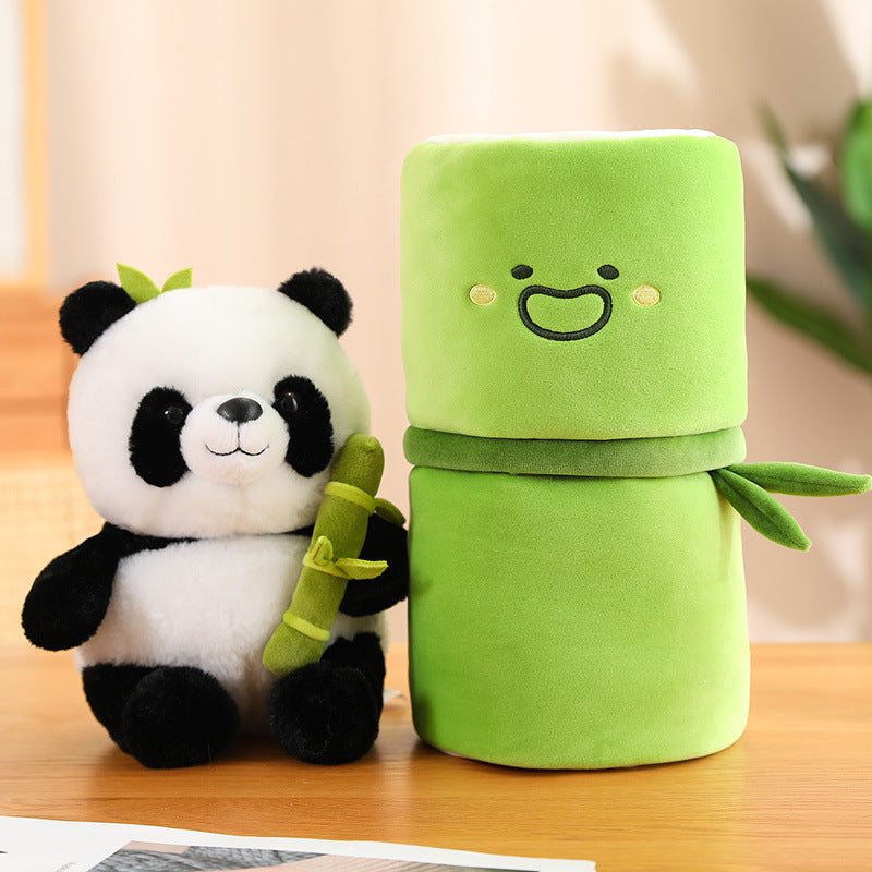 Plush panda and green plush toy with face on a wooden surface