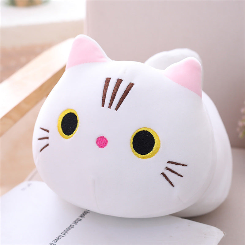 Plush cat toy with pink ears and black eyes on a light surface