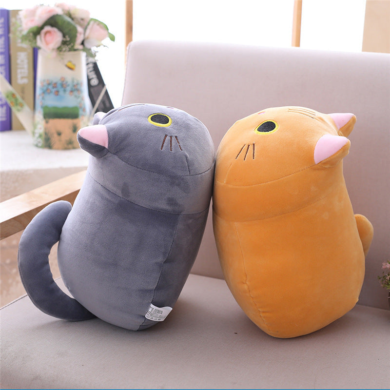 Two plush toys, one gray and one orange, sitting on a light-colored surface.