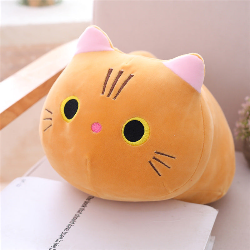 Plush cat pillow on a surface with a blurred background