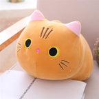 Plush cat pillow on a surface with a blurred background