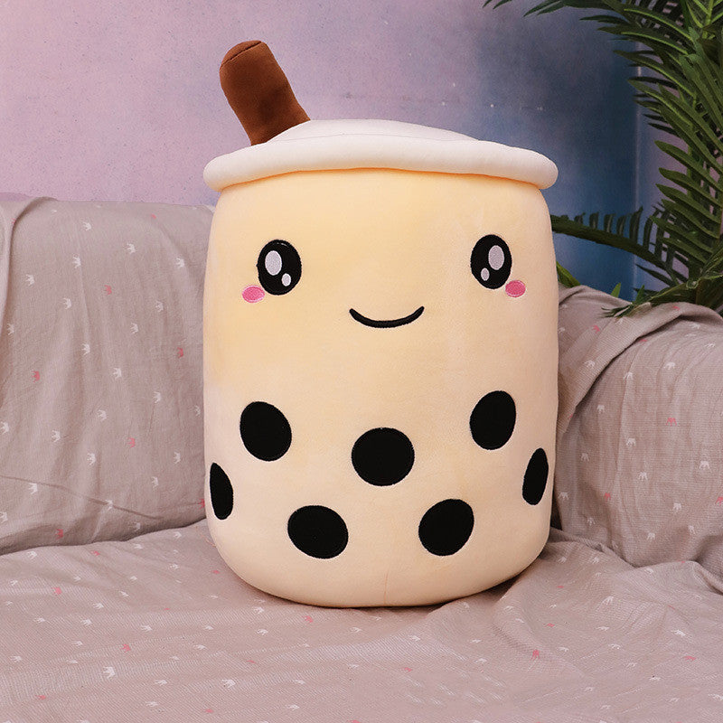 Cute plush toy resembling a bubble tea cup on a bed