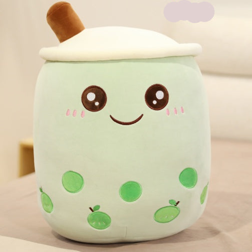 Plush toy resembling a green bubble tea with a smiling face on a beige background