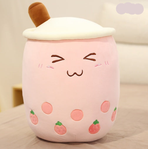 Plush toy resembling a pink bubble tea with a brown straw on a light background