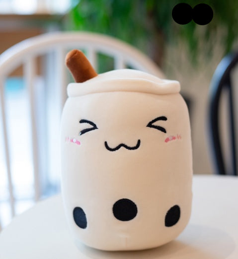 Plush toy resembling a bubble tea cup with a face on a blurred background