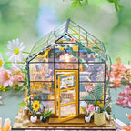 Miniature model of a greenhouse with plants and flowers on a blurred natural background