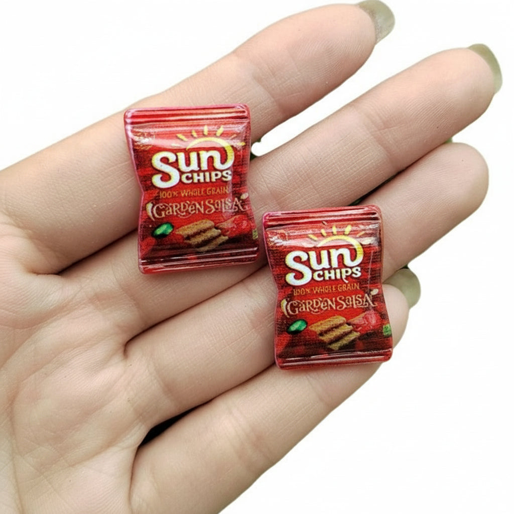 Two miniature Sun Chips packages held between fingers with measurements indicated.