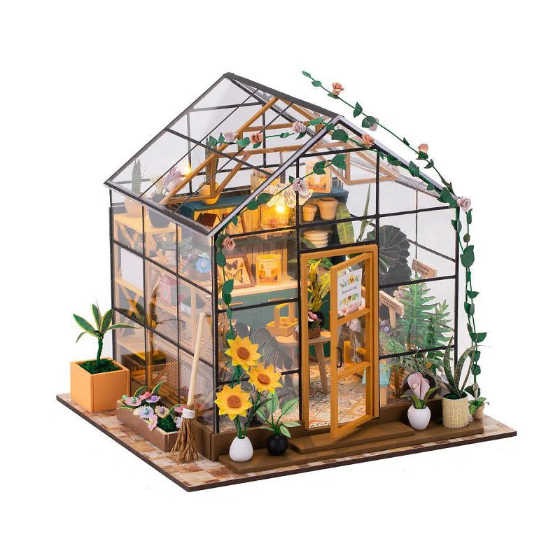 Model of a miniature greenhouse with plants and decor on a white background