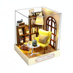 Miniature model of a cozy room with a yellow chair, bookshelf, and lamp, with dimensions indicated.