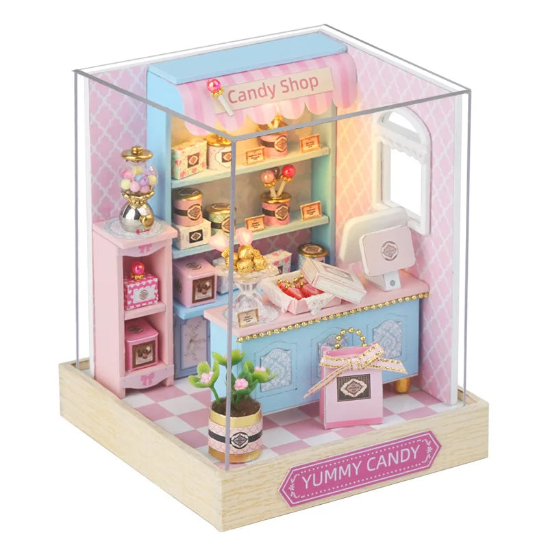 Miniature candy shop model in a clear display case with 'Yummy Candy' branding.