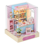 Miniature candy shop model in a clear display case with 'Yummy Candy' branding.