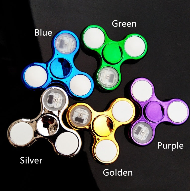 Five fidget spinners in different colors with labels on a black background
